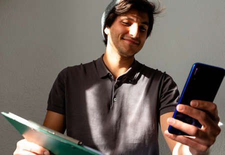 side view of high school or college student studying and writing in a notebook on a desk with a laptopの写真素材