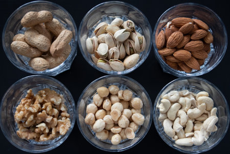 a mixture of nuts (peanuts, pistachios, almonds, walnuts, hazelnut, cashew) in glasses from top view...