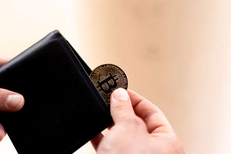 crypto bitcoin inside of a wallet with a golden card, representing crypto currency, investment and savings concept photoの写真素材