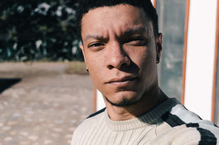 Close-up of young man with serious look and freckles on his faceの写真素材