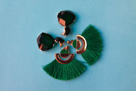 green earrings on blue backgroundの写真素材
