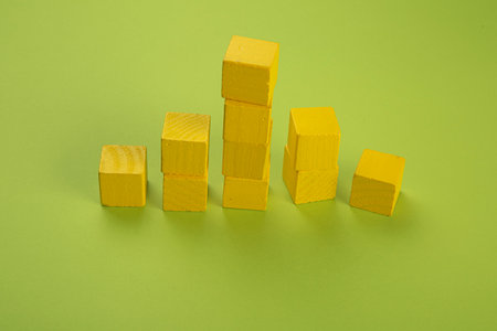 Yellow wooden chips in the form of a tower on a light green background