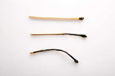 Small burnt wooden matches on white backgroundの写真素材