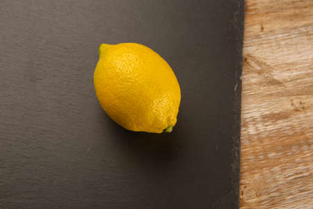 One yellow lemon on blackboard