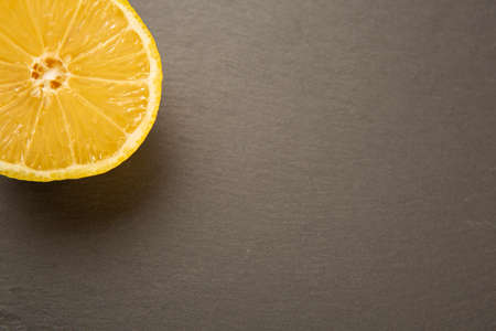 half yellow lemon on slateの写真素材
