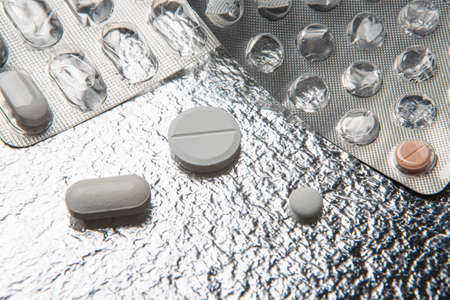 Different medicines and pills on silver colored backgroundの写真素材