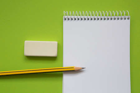 Blank notepad with pencil on light green backgroundの写真素材