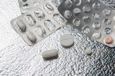 Different medicines and pills on silver colored backgroundの写真素材