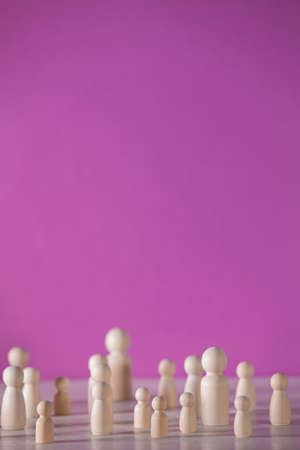 Wooden figures in the form of people on a colored background representing a social concentrationの写真素材