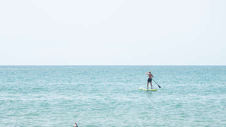 Silhouette of a man kayaking in the distance on the waters of the Mediterranean Seaの写真素材