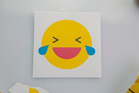 Square piece of paper with an emoji crying with laughter