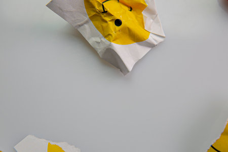Square piece of paper with a yellow smiley faceの写真素材