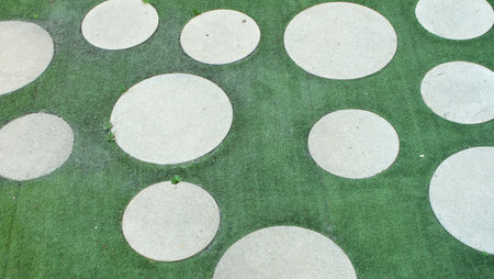 Design of an outdoor garden consisting of rectangular and round shapes of gray concrete on...