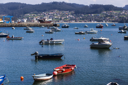 Boats in the Galician harbor with fishers fishingのeditorial素材