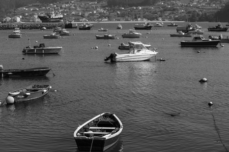 Boats in the Galician harbor with fishers fishingのeditorial素材