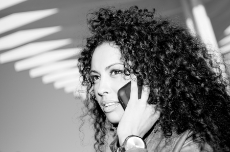 Portrait of pretty blak woman in urban background talking on phone の写真素材