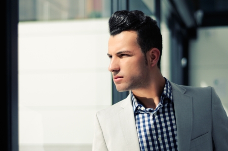 Portrait of a young handsome man, model of fashion, wearing jacket and shirt in urban backgroundの写真素材