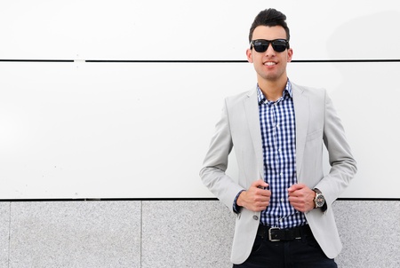 Portrait of a young handsome man, model of fashion, wearing tinted sunglasses