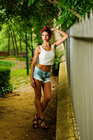 Portrait of a pin-up girl  American style, in a garden, wearing jeans and t-shirtの写真素材