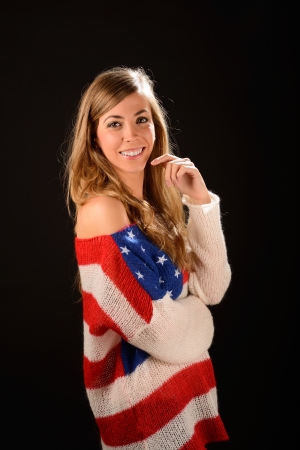 Portrait of a beautiful blonde girl wearing a sweater with the flag of United Statesの写真素材