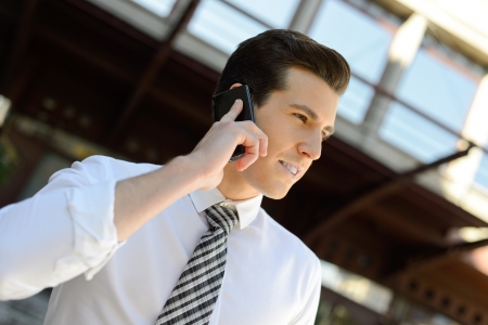 Portrait of an attractive businessman making a call using a smart phone in an office buildingの写真素材