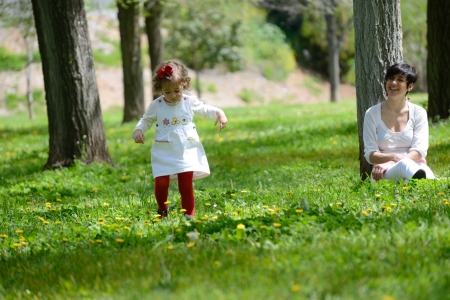 Portrait of mother and little girl playing in the parkの写真素材