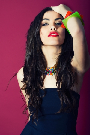 Beauty portrait of young woman on red background  Wearing braceletsの写真素材