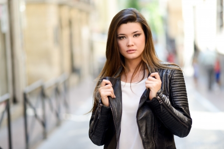 Portrait of beautiful japanese woman in urban background wearing leather jacketの写真素材