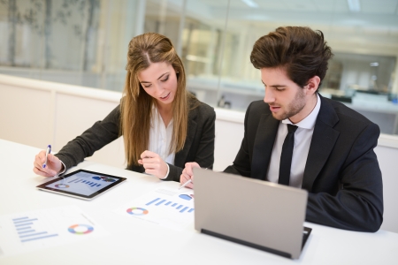 Portrait of business man and woman working around table in modern office の写真素材