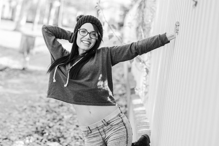 Portrait of brunette young woman wearing casual clothes, eyeglasses and hat, in urban backgroundの写真素材