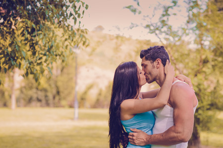 Attractive young couple kissing in a beautiful parkの写真素材