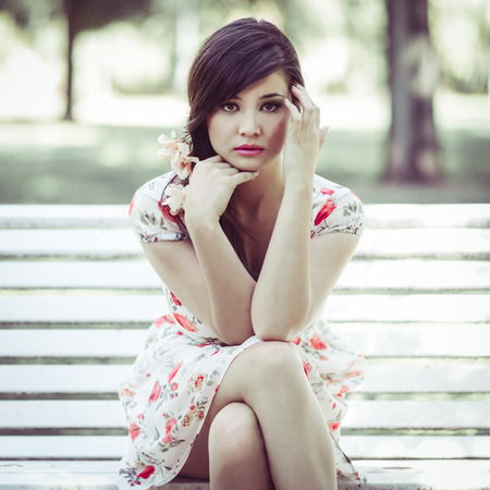 Close-up portrait of young beautiful japanese woman with pink and red flowers, model is an asian beauty の写真素材