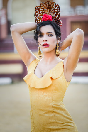 Portrait of a pretty woman, model of fashion, wearing a dress in a bullring. Spanish styleの写真素材