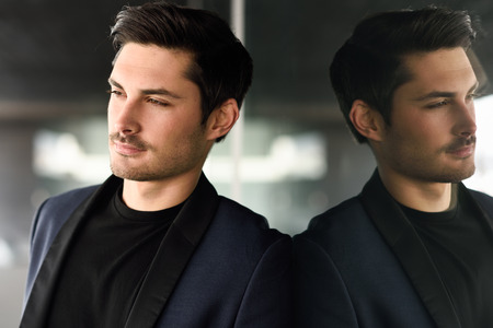Portrait of an attractive man, model of fashion, wearing modern suit.