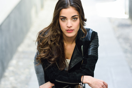 Portrait of young woman in urban background wearing casual clothes looking at cameraの写真素材