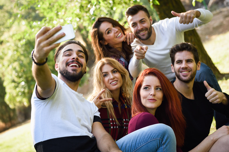 Group of friends taking selfie in urban park. Five young people wearing casual clothes.の写真素材