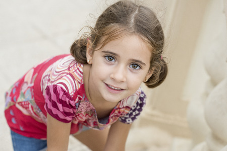Adorable little girl combed with pigtails outdoors.の写真素材