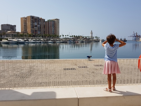 Little girl looking at the Port of Malaga in Andalusia, Spain.の写真素材