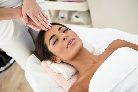 Arab woman receiving head massage in spa wellness center. Beauty and Aesthetic concepts.の写真素材