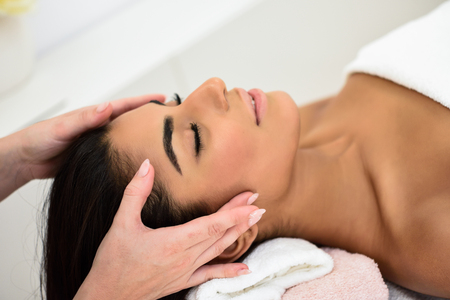 Arab young woman receiving head massage in spa wellness center. Beauty and Aesthetic concepts.の写真素材