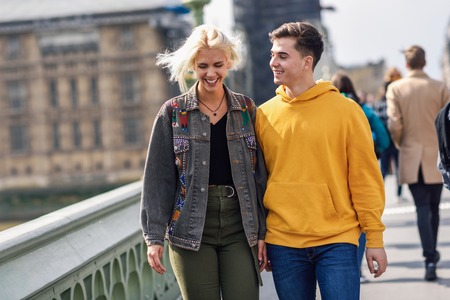 Happy couple by westminster bridge, River Thames, London. UK. Young couple of friends enjoying view...
