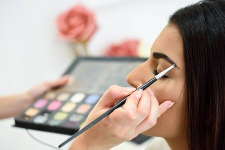 Makeup artist putting make-up on an womans eyebrowsの写真素材