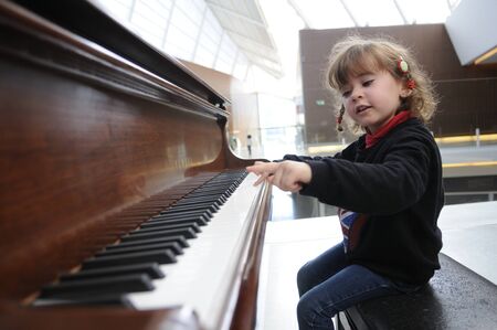 little girl having fun playing the pianoの写真素材