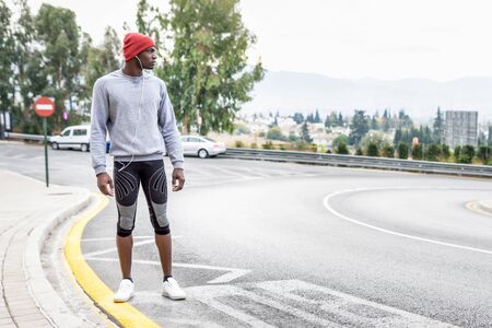 Black man running upstairs outdoors in urban backgroundの写真素材