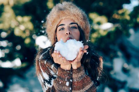 Young woman enjoying the snowy mountains in winterの写真素材