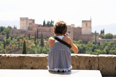 Little girl making photo with DSLR camera to the Alhambra.