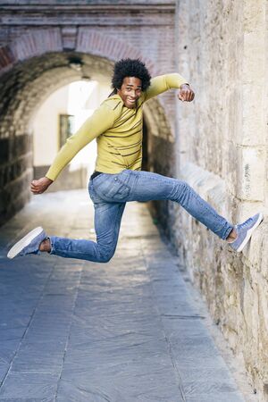 Black man with afro hair jumping for joy