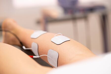 Electro stimulation in physical therapy to a young womanの写真素材