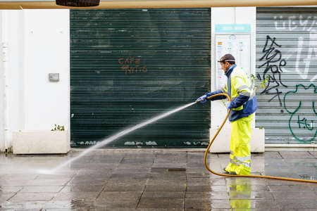 GRANADA, SPAIN, 23RD APRIL, 2020 Hose worker who waters the city streetのeditorial素材