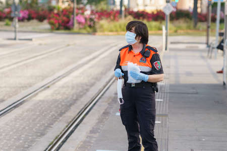 Civil protection woman handing out masks to protect against Covid-19のeditorial素材